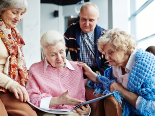 A group of elderly individuals reminiscing over a photo album